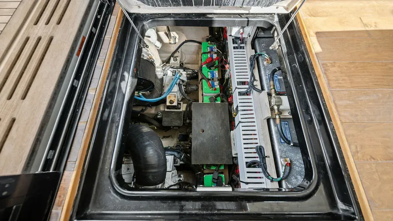 Slide: The Image of Engine Compartment Access Hatch This image showcases the engine compartment of the 2018 Sea Ray 400 Fly, accessible via a well-designed hatch. The compartment is neatly organized, housing essential mechanical and electrical systems. The layout facilitates ease of maintenance, with visib - 7762716