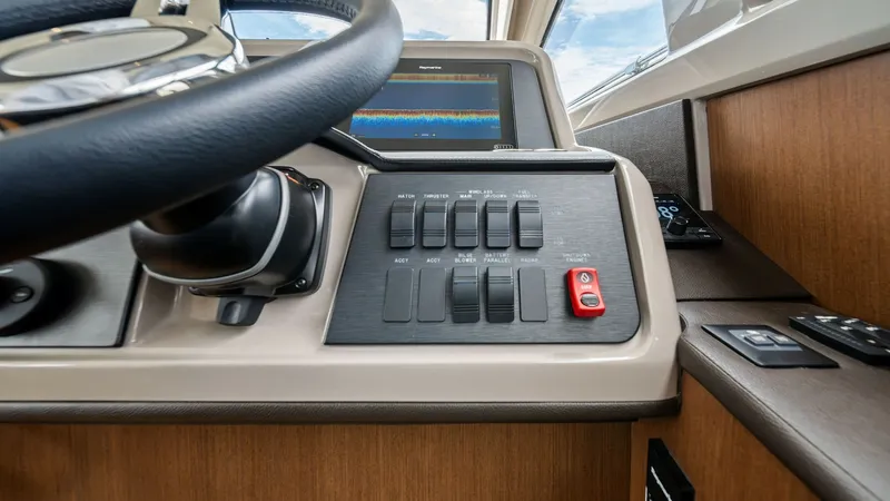 Slide: The Image of Helm Console with Navigation Display The helm of the 2018 Sea Ray 400 Fly features a sleek, modern console equipped with a state-of-the-art navigation display. The ergonomic steering wheel offers precise control, while the intuitive switch panel ensures easy operation of vessel systems. High - 7762692