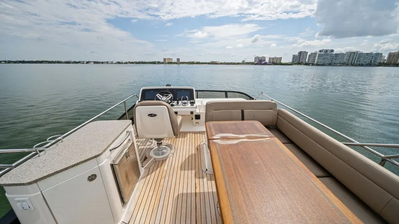 Slide: The Image of Flybridge with Helm and Seating Area This image showcases the spacious flybridge of the 2018 Sea Ray 400 Fly, featuring a sleek helm station with modern controls. The area is equipped with comfortable wrap-around seating and a stylish teak table, perfect for entertaining while enjoying panor - 7762711