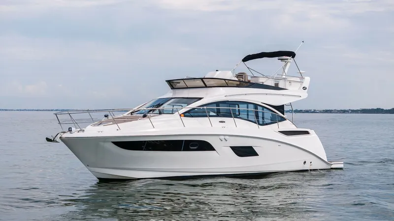 Slide: The Image of Side Profile of Sea Ray 400 Fly The image showcases the sleek side profile of the 2018 Sea Ray 400 Fly, highlighting its modern design and elegant lines. The flybridge is equipped with a stylish bimini top, providing shade and comfort for outdoor relaxation. Large windows along the hull - 7762726