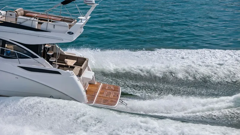 Slide: The Image of Aft Deck and Swim Platform in Action This dynamic image showcases the aft deck and swim platform of the 2018 Sea Ray 400 Fly, Tee Time III, gliding over the water. The teak swim platform offers easy water access, while the spacious aft seating area provides a comfortable spot to relax and en - 7762741