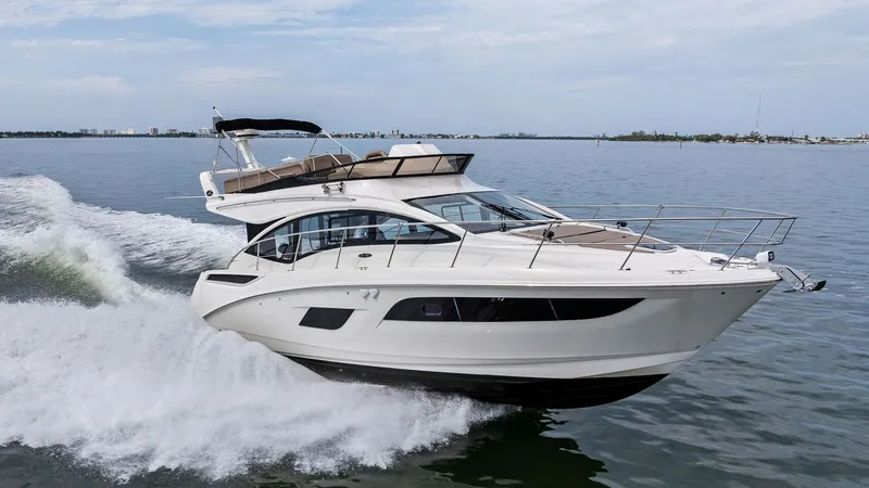 Slide: The Image of Dynamic Side Profile Underway The 2018 Sea Ray 400 Fly, Tee Time III, showcases a sleek and modern design as it glides effortlessly through the water. With its aerodynamic silhouette and expansive flybridge, this vessel offers luxurious comfort and style. The elegant windows provide a - 7762736