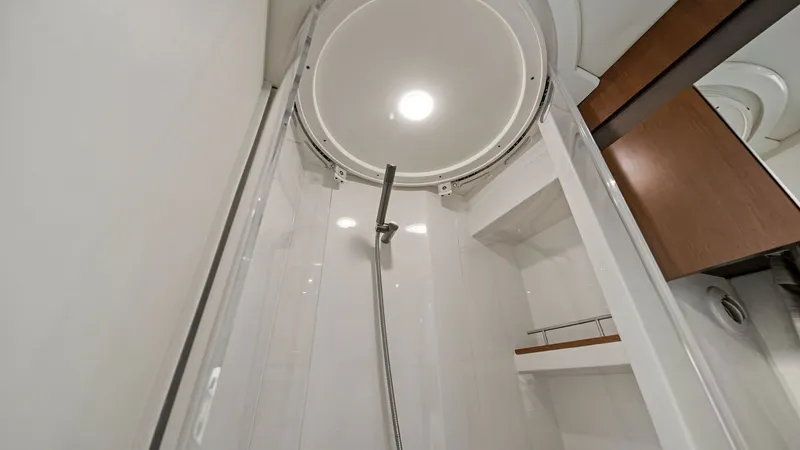 Slide: The Image of Modern Shower Enclosure This image showcases the sleek and modern shower enclosure aboard the 2018 Sea Ray 400 Fly, Tee Time III. The space features a contemporary circular overhead design with integrated lighting, creating a bright and inviting atmosphere. Its high-gloss surfac - 7762701