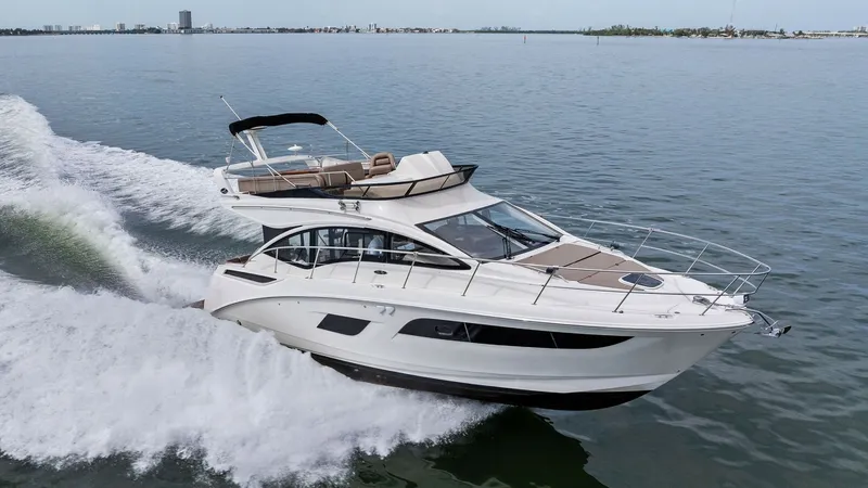 Slide: The Image of Dynamic Flybridge and Exterior View The 2018 Sea Ray 400 Fly, Tee Time III, glides effortlessly through the water showcasing its sleek, modern design. The flybridge offers ample seating with a commanding view, perfect for entertaining or relaxing while underway. The streamlined hull and exp - 7762737