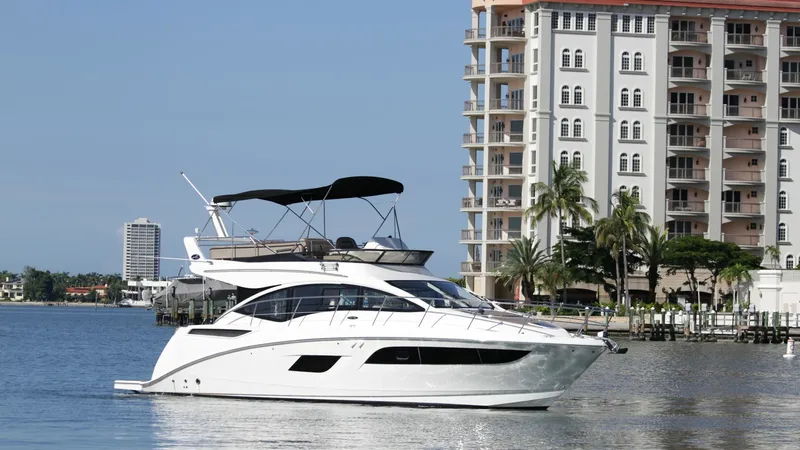 Slide: The Image of Starboard Profile with Flybridge View This image showcases the sleek starboard profile of the 2018 Sea Ray 400 Fly, named Tee Time III. The flybridge is elegantly designed with a stylish bimini top, offering a perfect vantage point for navigating or leisure. The hull's graceful lines and mode - 7762733