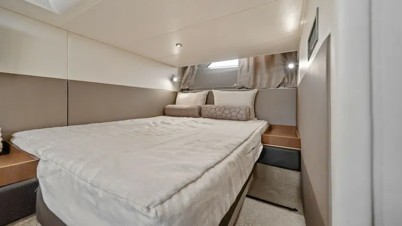 Slide: The Image of Guest Stateroom with Plush Bedding This inviting guest stateroom on the 2018 Sea Ray 400 Fly features a comfortable double berth adorned with luxurious, soft bedding. The room is elegantly designed with neutral tones, creating a serene and relaxing atmosphere. Ample natural light filters t - 7762709