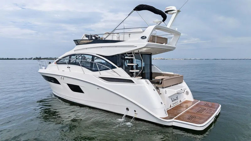 Slide: The Image of Aft View with Swim Platform The 2018 Sea Ray 400 Fly showcases its elegant design from the aft view, featuring a spacious swim platform ideal for water activities. The sleek lines and modern styling emphasize luxury, complemented by the open flybridge area perfect for entertaining. - 7762723