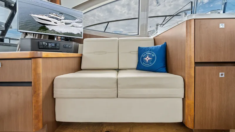 Slide: The Image of Salon Seating with Entertainment Center The salon of the 2018 Sea Ray 400 Fly features plush cream leather seating, offering a comfortable and stylish space for relaxation. A built-in entertainment center, complete with a flat-screen TV, enhances the onboard experience. Natural light pours in t - 7762696