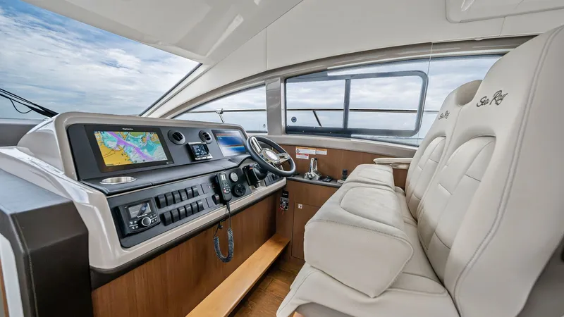 Slide: The Image of Flybridge Helm Station The helm station on the Sea Ray 400 Fly offers a sleek, modern design with state-of-the-art navigation equipment. Luxurious leather seating provides comfort and style, while large windows offer expansive views for an enhanced piloting experience. The ergo - 7762686