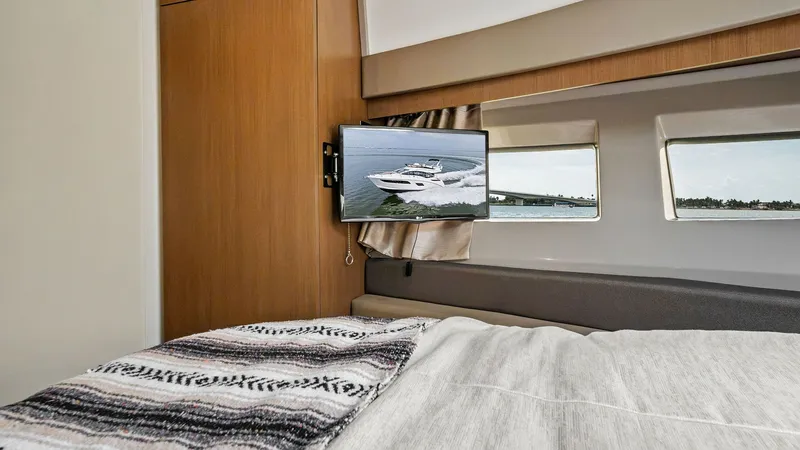 Slide: The Image of Cozy Stateroom with TV View The stateroom of the 2018 Sea Ray 400 Fly offers a comfortable retreat with a plush bed and stylish wood finishes. A mounted flat-screen TV provides entertainment, while large windows allow natural light to enhance the space. The elegant design and though - 7762699
