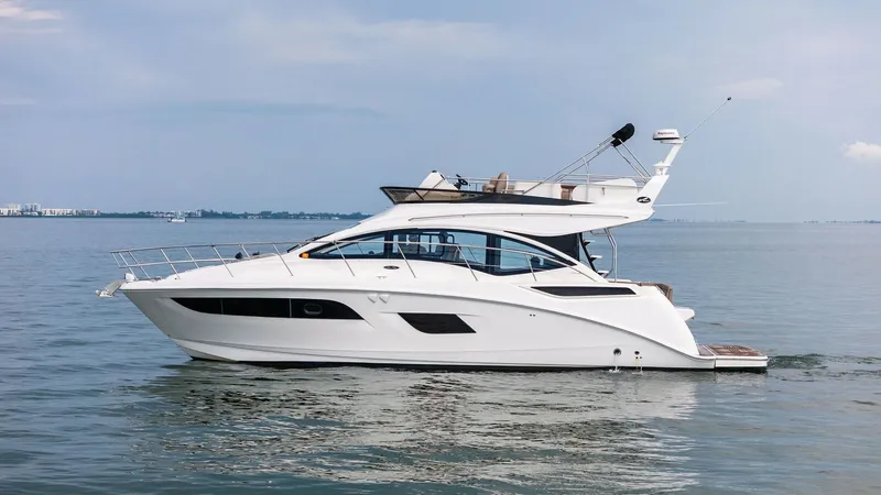 Slide: The Image of Side Profile of Sea Ray 400 Fly This image showcases the sleek side profile of the 2018 Sea Ray 400 Fly, Tee Time III. The elegant lines and modern design are complemented by large windows, providing ample natural light and stunning views. The flybridge offers additional space for relax - 7762725