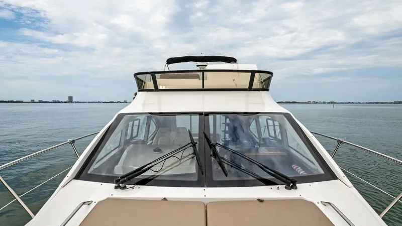 Slide: The Image of Flybridge and Helm View This image showcases the sleek flybridge of the 2018 Sea Ray 400 Fly, offering a panoramic view of the surrounding waters. The flybridge is equipped with comfortable seating and modern controls, providing an ideal vantage point for navigation. The clean l - 7762752