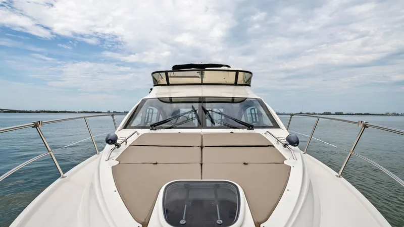Slide: The Image of Bow View with Sunpad Lounge The bow of the 2018 Sea Ray 400 Fly, Tee Time III, features a spacious sunpad lounge perfect for relaxation. The sleek design offers unobstructed views, ideal for enjoying the open water. Stainless steel railings and the streamlined windshield enhance bot - 7762750