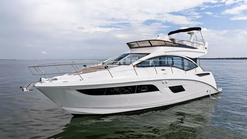 Slide: The Image of Starboard Exterior View of Flybridge This image showcases the sleek starboard side of the 2018 Sea Ray 400 Fly, Tee Time III. The vessel's elegant lines and modern design are complemented by expansive windows, providing ample natural light to the interior. The flybridge offers a commanding v - 7762720