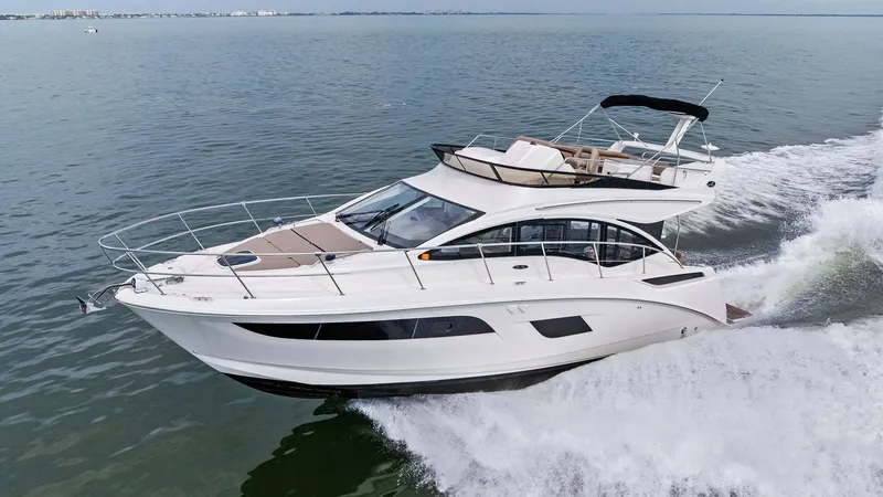Slide: The Image of Dynamic Flybridge and Bow View The 2018 Sea Ray 400 Fly, Tee Time III, showcases its sleek flybridge and spacious bow as it cruises through open waters. The flybridge features elegant seating and a commanding helm, perfect for enjoying panoramic views. The stylish design and smooth lin - 7762744