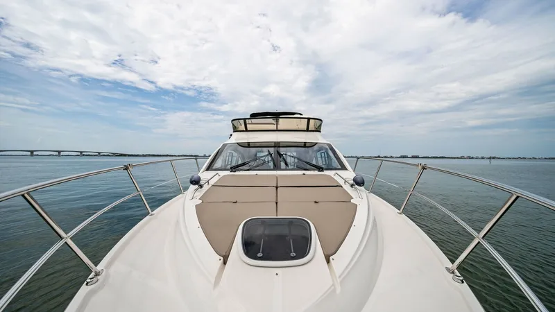 Slide: The Image of Bow View with Sunpad Seating This image showcases the sleek bow of the 2018 Sea Ray 400 Fly, Tee Time III, offering a spacious sunpad area perfect for relaxation. The polished stainless steel railings provide safety and elegance, while the expansive deck enhances the open sea experie - 7762749