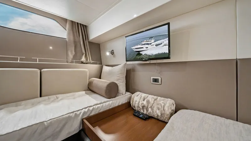 Slide: The Image of Guest Stateroom with Twin Beds This cozy guest stateroom features twin beds with plush bedding, providing comfort and relaxation. A mounted flat-screen TV offers entertainment, while a large window allows natural light to enhance the inviting ambiance. The neutral tones and sleek desig - 7762707