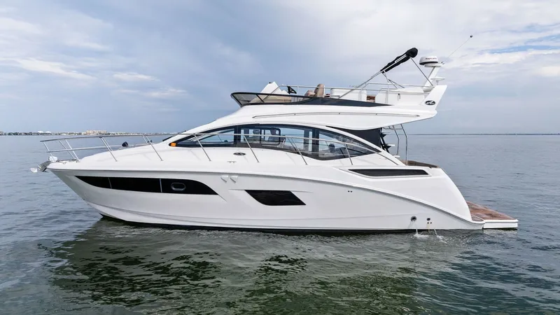 Slide: The Image of Profile View of Sea Ray 400 Fly The 2018 Sea Ray 400 Fly, 'Tee Time III', showcases its sleek and modern exterior design. The profile view highlights the spacious flybridge with ample seating, perfect for entertaining. The hull's elegant lines and large windows offer a blend of style an - 7762719