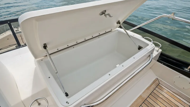 Slide: The Image of Spacious Aft Deck Storage Compartment This image showcases a generous storage compartment located on the aft deck of the 2018 Sea Ray 400 Fly, Tee Time III. The compartment offers ample space for storing essential gear, with a durable lid and secure latch for easy access and safety. The sleek - 7762715