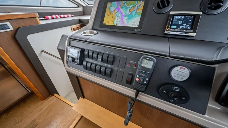 Slide: The Image of Modern Helm Station with Electronics The helm station of the 2018 Sea Ray 400 Fly features a sleek, modern design with advanced navigation electronics. A large multifunction display is prominently set into the console, offering clear charts and data for efficient navigation. The control pane - 7762691