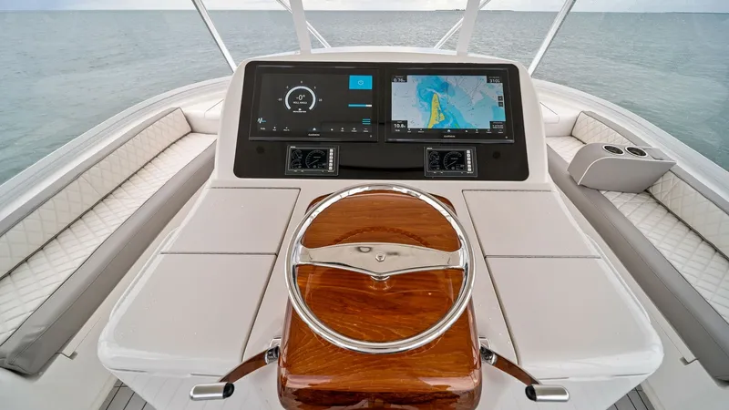 Slide: The Image of Flybridge Helm Station with Electronics The helm station of the Viking 55 Convertible 'Rosita' features state-of-the-art navigation electronics, providing a seamless command center for the captain. The polished wooden wheel and ergonomic design enhance functionality, while the dual screens offe - 7584904