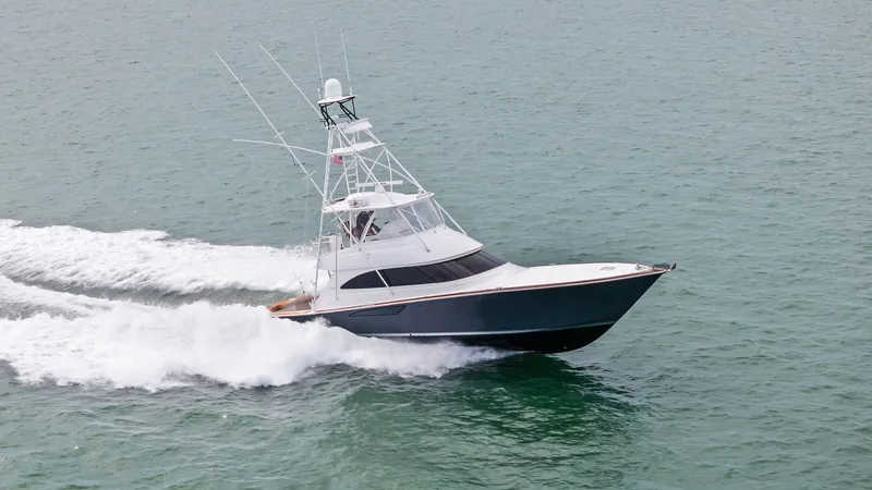 Slide: The Image of Viking 55 Convertible Cruising The 2015 Viking 55 Convertible, Rosita, is captured elegantly slicing through the water with its sleek hull and commanding presence. This vessel features a robust flybridge with a full array of navigation equipment, ideal for sportfishing or leisurely cru - 7584948