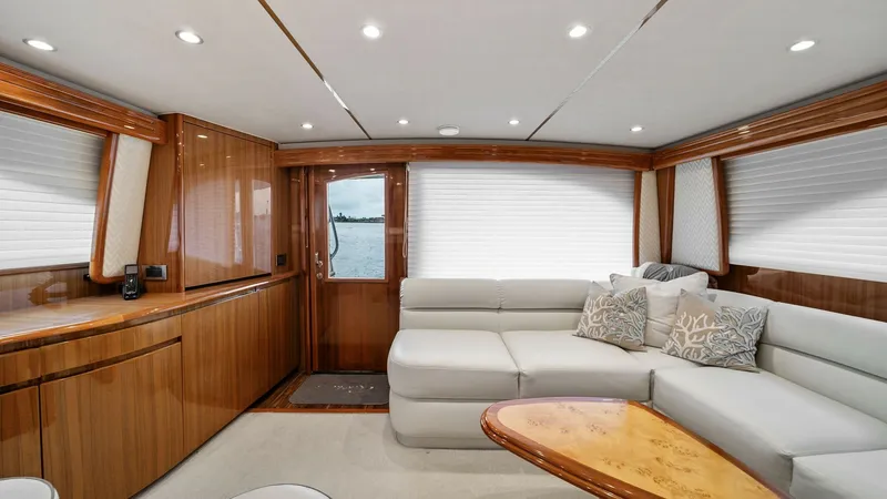 Slide: The Image of Spacious Salon with Elegant Furnishings The salon of the Viking 55 Convertible 'Rosita' features a luxurious L-shaped sofa complemented by a polished wood coffee table, creating a sophisticated and inviting atmosphere. The high-gloss cabinetry and soft overhead lighting enhance the room's warmt - 7584871