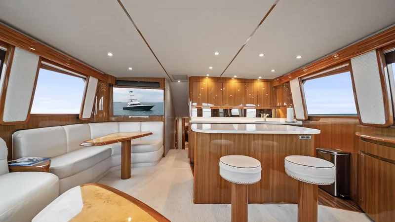 Slide: The Image of Spacious Salon and Galley View The salon of the Viking 55 Convertible exudes luxury with its rich wood finishes and plush seating, offering a comfortable space for relaxation. The open layout seamlessly connects to the galley, equipped with modern appliances and ample counter space, pe - 7584879
