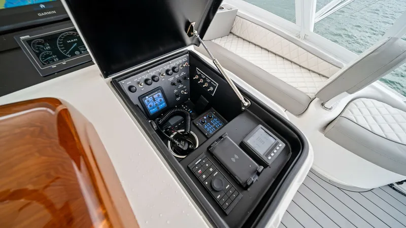 Slide: The Image of Flybridge Helm Console and Seating The image showcases the helm console on the flybridge of the 2015 Viking 55 Convertible, featuring advanced navigation and control systems neatly arranged within a sleek compartment. The surrounding area includes plush, diamond-stitched seating, providing - 7584909