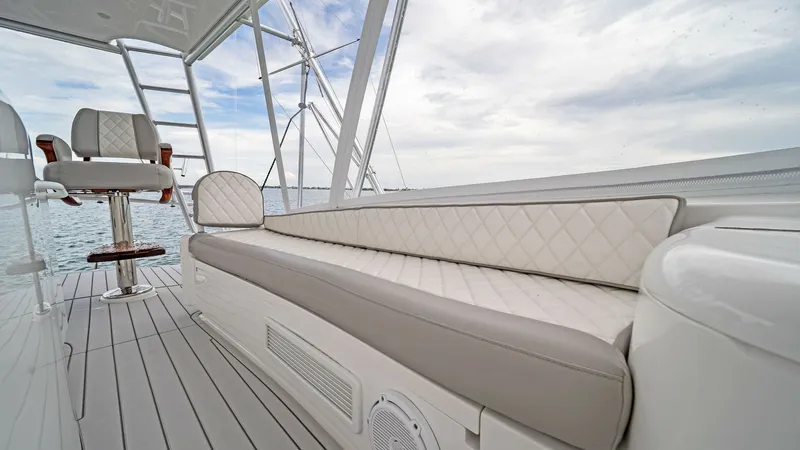 Slide: The Image of Flybridge Seating Area The flybridge of the Viking 55 Convertible features luxurious, diamond-stitched seating, offering comfort and style. The area is complemented by sleek, durable flooring and modern helm chairs, providing an ideal space for navigation and relaxation. Expans - 7584899