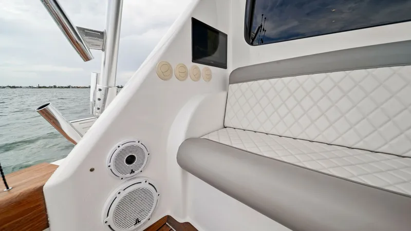 Slide: The Image of Cockpit Seating Area with Speakers This image showcases the elegant cockpit seating area of the 2015 Viking 55 Convertible, featuring plush diamond-stitched upholstery for comfort and style. Integrated speakers provide an enhanced audio experience, perfect for entertaining while cruising. - 7584859