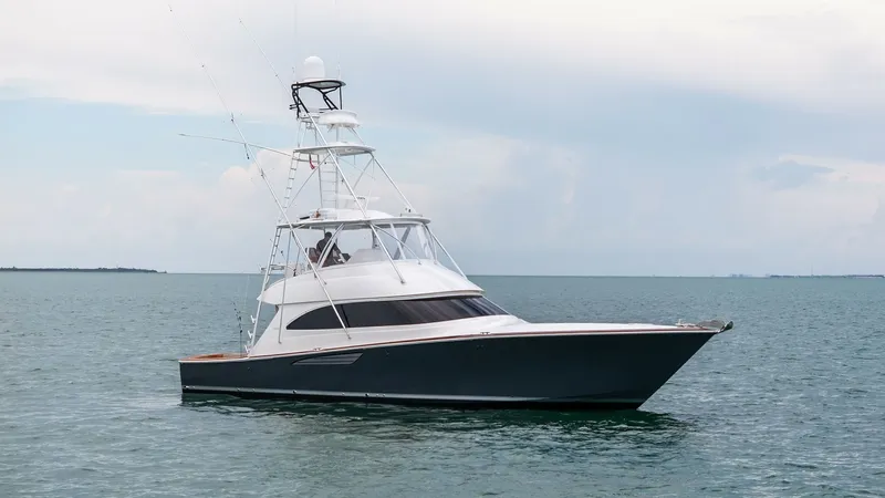 Slide: The Image of Side Profile of Viking 55 Convertible This image showcases the sleek side profile of the 2015 Viking 55 Convertible, highlighting its elegant hull design and spacious flybridge. The vessel's sturdy construction is evident, with a commanding tower for enhanced visibility and sportfishing capab - 7584933