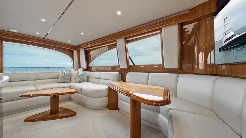 Slide: The Image of Luxurious Salon with Panoramic Views This elegant salon on the 2015 Viking 55 Convertible 'Rosita' boasts plush, cream-colored seating and beautifully crafted wooden accents. Large windows offer stunning panoramic views, filling the space with natural light and creating an inviting atmospher - 7584878