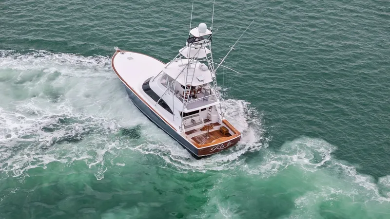Slide: The Image of Aerial View of Viking 55 Convertible This aerial shot highlights the sleek design and powerful presence of the 2015 Viking 55 Convertible. The vessel is shown cutting through the water with ease, showcasing its robust hull and spacious aft deck. The flybridge and tower add to its commanding - 7584934