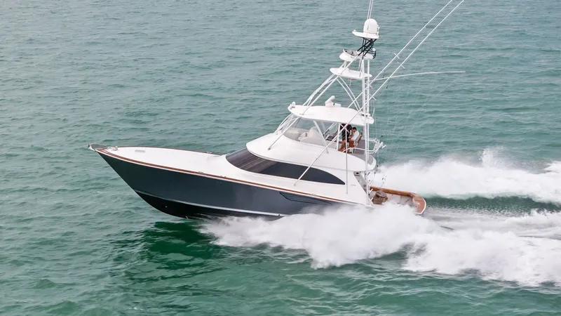 Slide: The Image of Viking 55 Convertible at Sea The 2015 Viking 55 Convertible, 'Rosita', showcases its sleek design and powerful performance as it cuts through the water. The vessel's elegant hull and spacious flybridge are highlighted, emphasizing its capability for both sportfishing and luxury cruis - 7584938