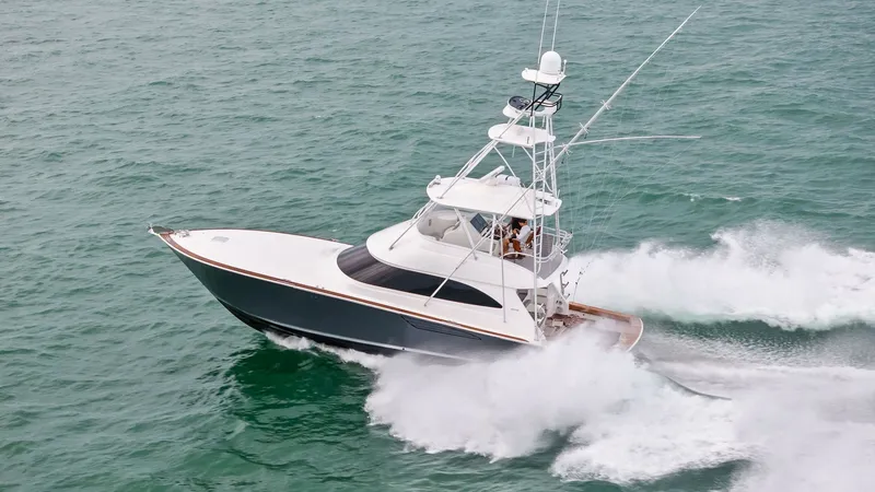 Slide: The Image of Aerial View of Viking 55 Convertible This dynamic aerial shot captures the Viking 55 Convertible cruising through the ocean with remarkable speed and agility. The sleek hull design and robust tower are prominently displayed, highlighting its sportfishing capabilities. The vessel's elegant ex - 7584937