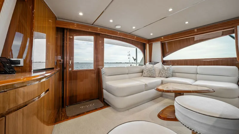Slide: The Image of Spacious Salon with Panoramic Views The salon of the 2015 Viking 55 Convertible 'Rosita' is elegantly designed with plush white seating and high-gloss wooden finishes, providing a luxurious atmosphere. Large windows and a glass door offer breathtaking panoramic views, enhancing the sense of - 7584877