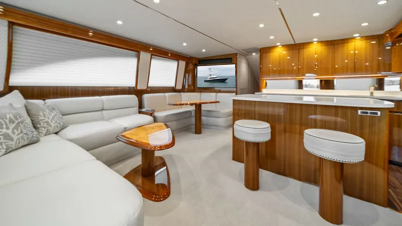 Slide: The Image of Spacious Salon with Open Galley The salon of the Viking 55 Convertible 'Rosita' features a luxurious and spacious seating area with plush, cream-colored upholstery. The open galley boasts high-gloss wood finishes and modern appliances, creating an inviting space for entertaining. Large - 7584867
