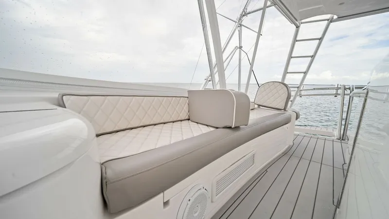 Slide: The Image of Flybridge Seating Area The flybridge of the 2015 Viking 55 Convertible 'Rosita' offers a stylish and comfortable seating area with plush, diamond-stitched cushions. This space provides an elevated vantage point for enjoying panoramic ocean views. The durable decking and sleek d - 7584896