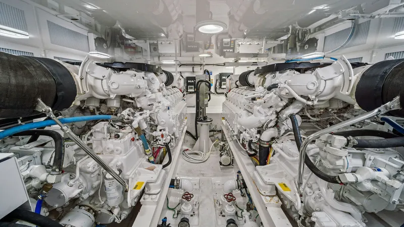 Slide: The Image of Engine Room with Dual Engines The engine room of the 2015 Viking 55 Convertible 'Rosita' showcases dual powerful engines, meticulously arranged for optimal performance. The pristine white finishes and organized layout highlight the vessel's commitment to engineering excellence. Ample - 7584915