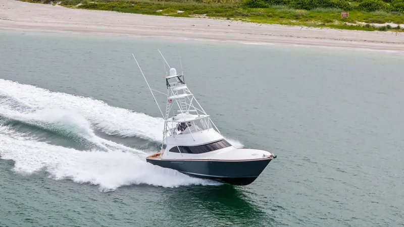 Slide: The Image of Aerial View of Viking 55 Convertible The 2015 Viking 55 Convertible, 'Rosita', is captured slicing through the water with impressive speed and elegance. This aerial view showcases the yacht's sleek hull design and robust flying bridge, perfect for both sportfishing and leisure cruising. The - 7584945