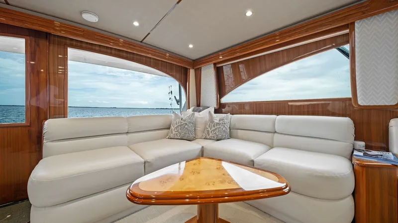 Slide: The Image of Elegant Salon with Ocean Views The salon of the 2015 Viking 55 Convertible 'Rosita' features luxurious cream leather seating, elegantly complemented by rich wood finishes. Large windows offer expansive ocean views, enhancing the sense of openness and light. The space is accentuated by - 7584875