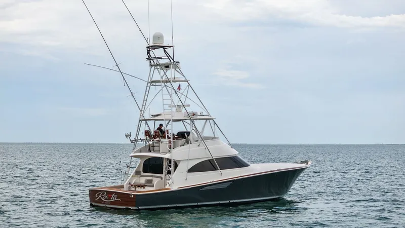 Slide: The Image of Side Profile with Tuna Tower The 2015 Viking 55 Convertible 'Rosita' is showcased with its sleek side profile, highlighting the impressive tuna tower. This vessel combines performance and elegance, featuring a spacious cockpit ideal for sportfishing. The modern design and robust stru - 7584930
