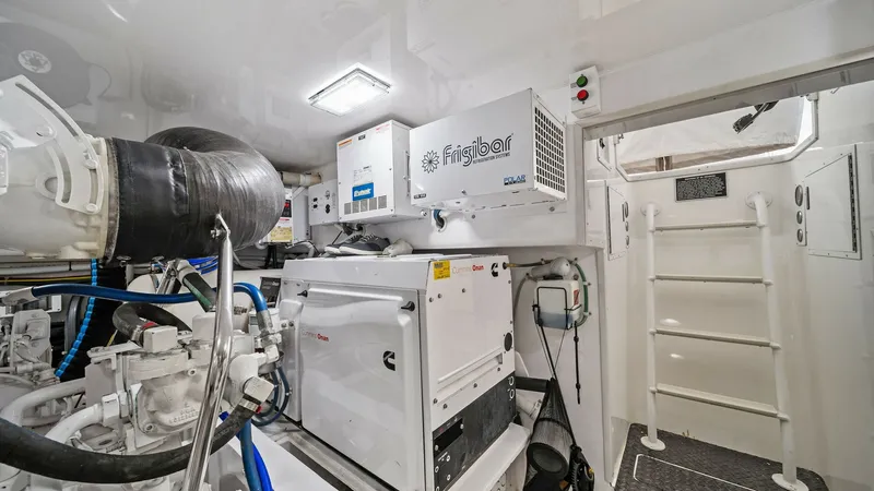 Slide: The Image of Engine Room with Generator The engine room of the 2015 Viking 55 Convertible showcases a well-organized layout featuring a powerful generator and advanced systems. Bright lighting and a white finish enhance visibility and cleanliness, ensuring easy maintenance and operation. The Fr - 7584918