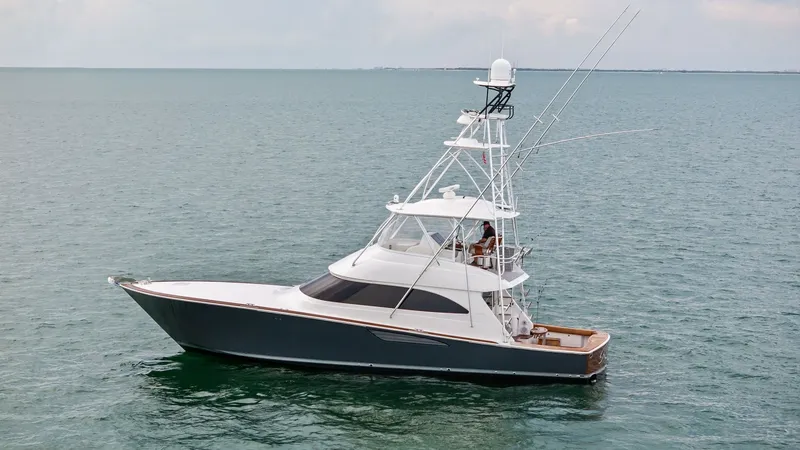 Slide: The Image of Portside View of Viking 55 Convertible This image showcases the sleek portside profile of the 2015 Viking 55 Convertible, 'Rosita'. The vessel's sporty and elegant design is complemented by a robust tuna tower, ideal for spotting game fish. The sophisticated hull lines and spacious cockpit hig - 7584924