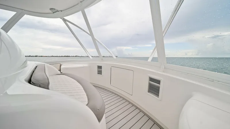 Slide: The Image of Flybridge Seating Area with Ocean View This image showcases the spacious flybridge seating area on the 2015 Viking 55 Convertible, 'Rosita.' The sleek white finish and plush seating provide a luxurious and comfortable environment for relaxation while enjoying panoramic ocean views. The design - 7584902