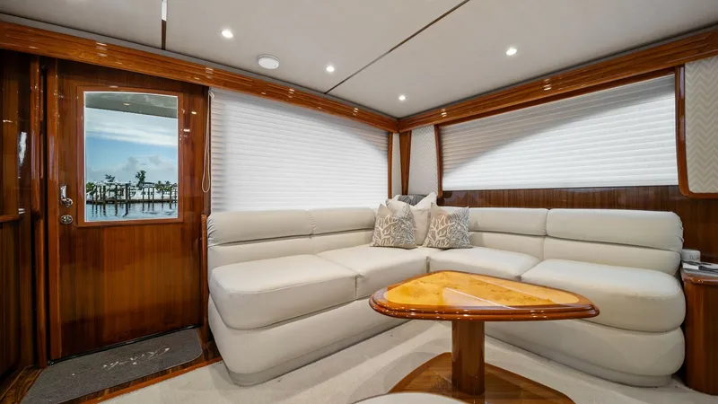 Slide: The Image of Luxurious Salon with Plush Seating The salon of the 2015 Viking 55 Convertible showcases elegant wood finishes and plush L-shaped seating, perfect for relaxation and entertainment. Natural light filters through the large windows, enhancing the warmth of the space. The high-gloss wooden tab - 7584860