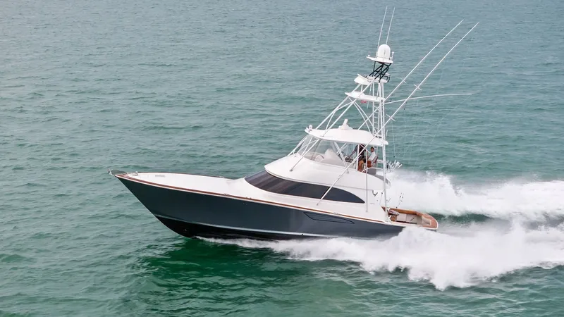 Slide: The Image of Dynamic Port View Underway The 2015 Viking 55 Convertible 'Rosita' gracefully cuts through the water, showcasing its sleek hull design and powerful performance. The flybridge offers an elevated vantage point, equipped with a robust radar and antennas. This vessel exemplifies a perf - 7584939