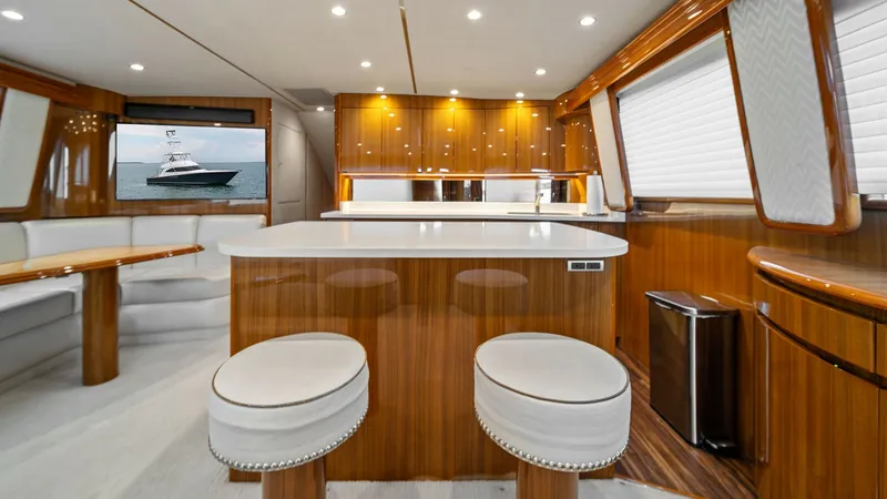 Slide: The Image of Luxurious Interior Salon with Galley The salon of the 2015 Viking 55 Convertible features an open layout with a sleek galley. It boasts glossy wood finishes and ample natural light through large windows. Comfortable seating and modern appliances enhance the onboard living experience, making - 7584868