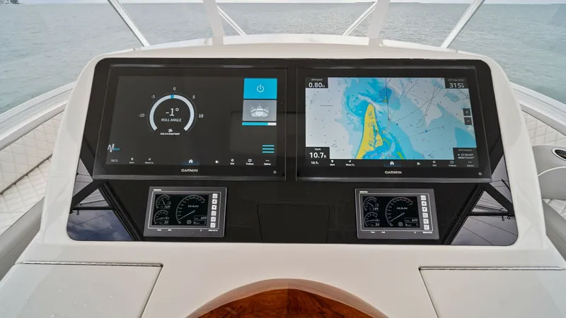 Slide: The Image of Helm Station with Dual Displays The helm station of the 2015 Viking 55 Convertible features dual Garmin displays, providing comprehensive navigation and system information at a glance. The sleek, modern design is complemented by a polished wood accent, offering both functionality and st - 7584907